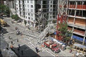 A large crane lies in the middle of a large New York City intersection.  The crane collapsed Friday May 30, 2008